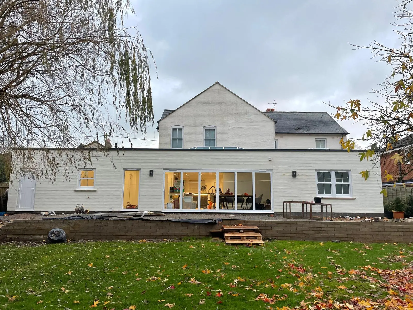 Full width single storey rear extension with sliding doors on a white rendered house by DBD Builders Ltd