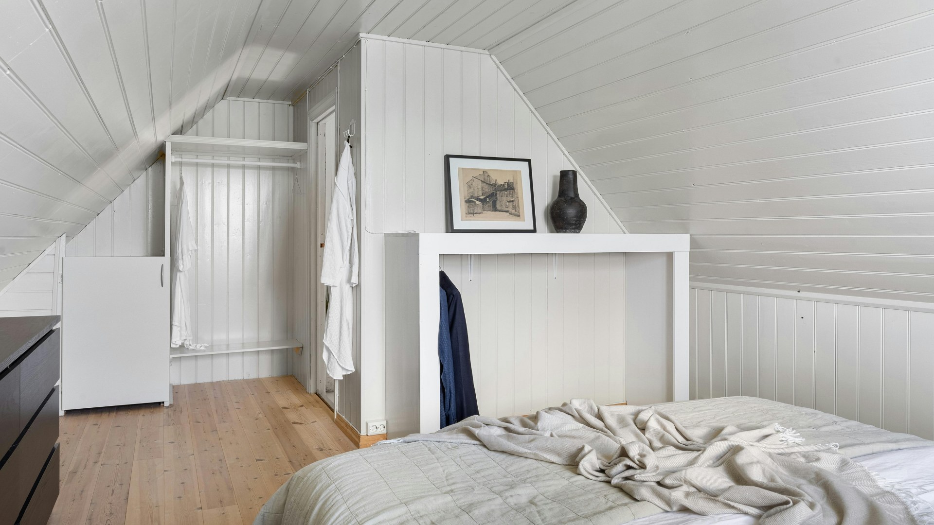 Finished loft conversion bedroom with white panelled sloping ceilings and timber flooring by DBD Builders Ltd